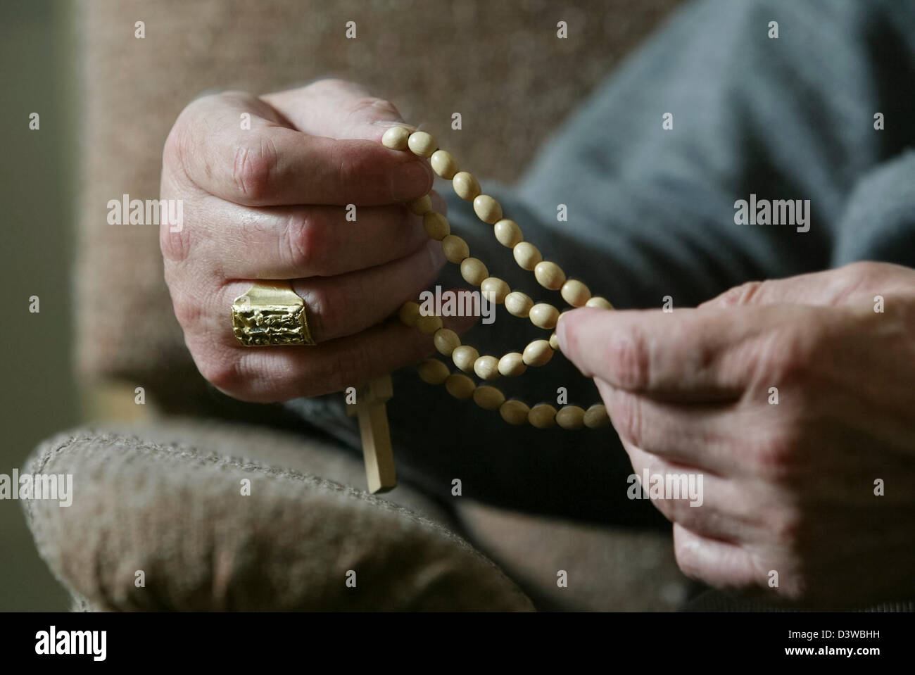 The hands of Cardinal Keith O'Brien, the most senior Roman Catholic cleric in Scotland, holding rosary beads Stock Photo