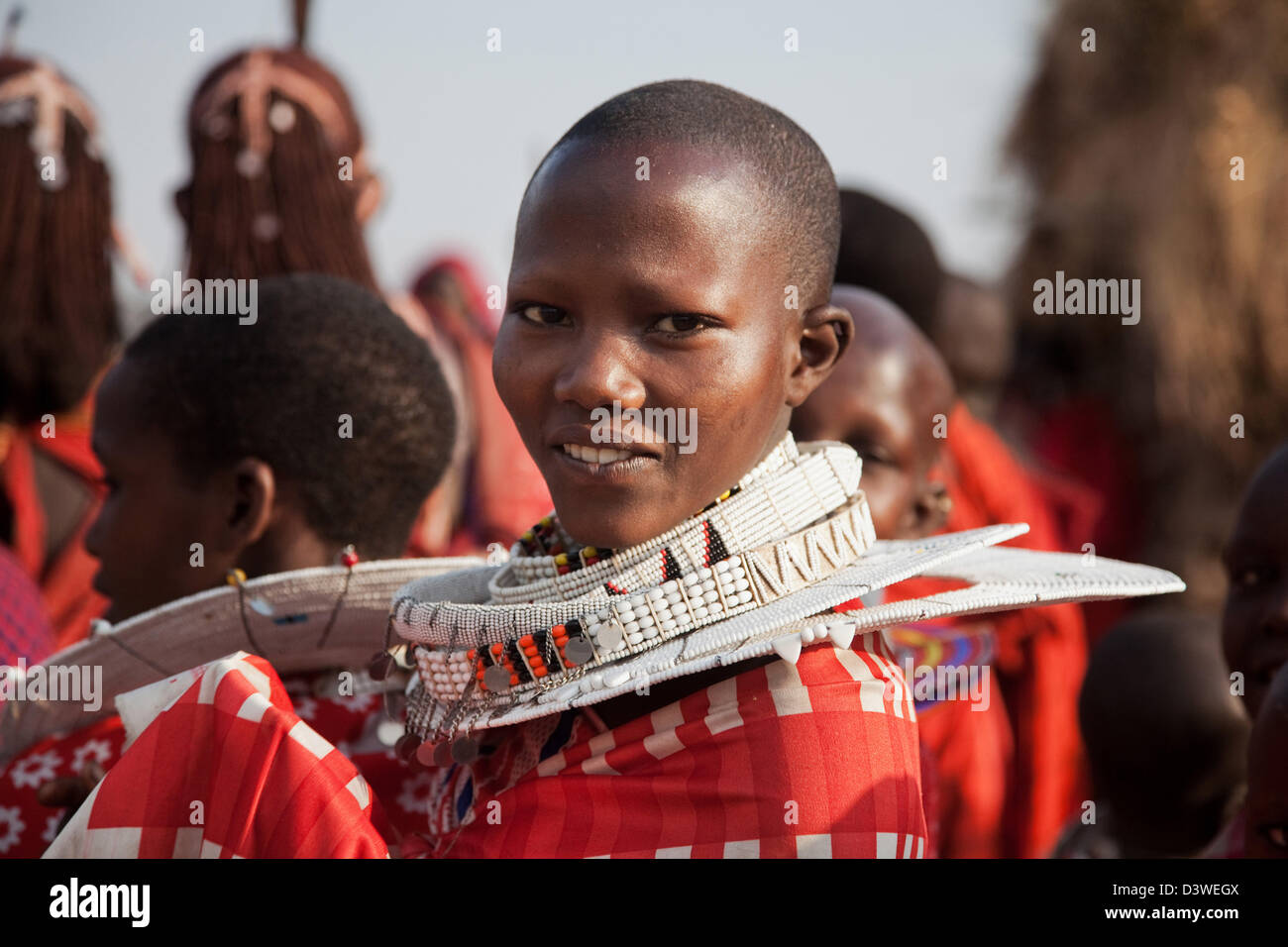 A young maasai girl in her best red shuka and fantastic bead necklaces at a wedding party. Stock Photo