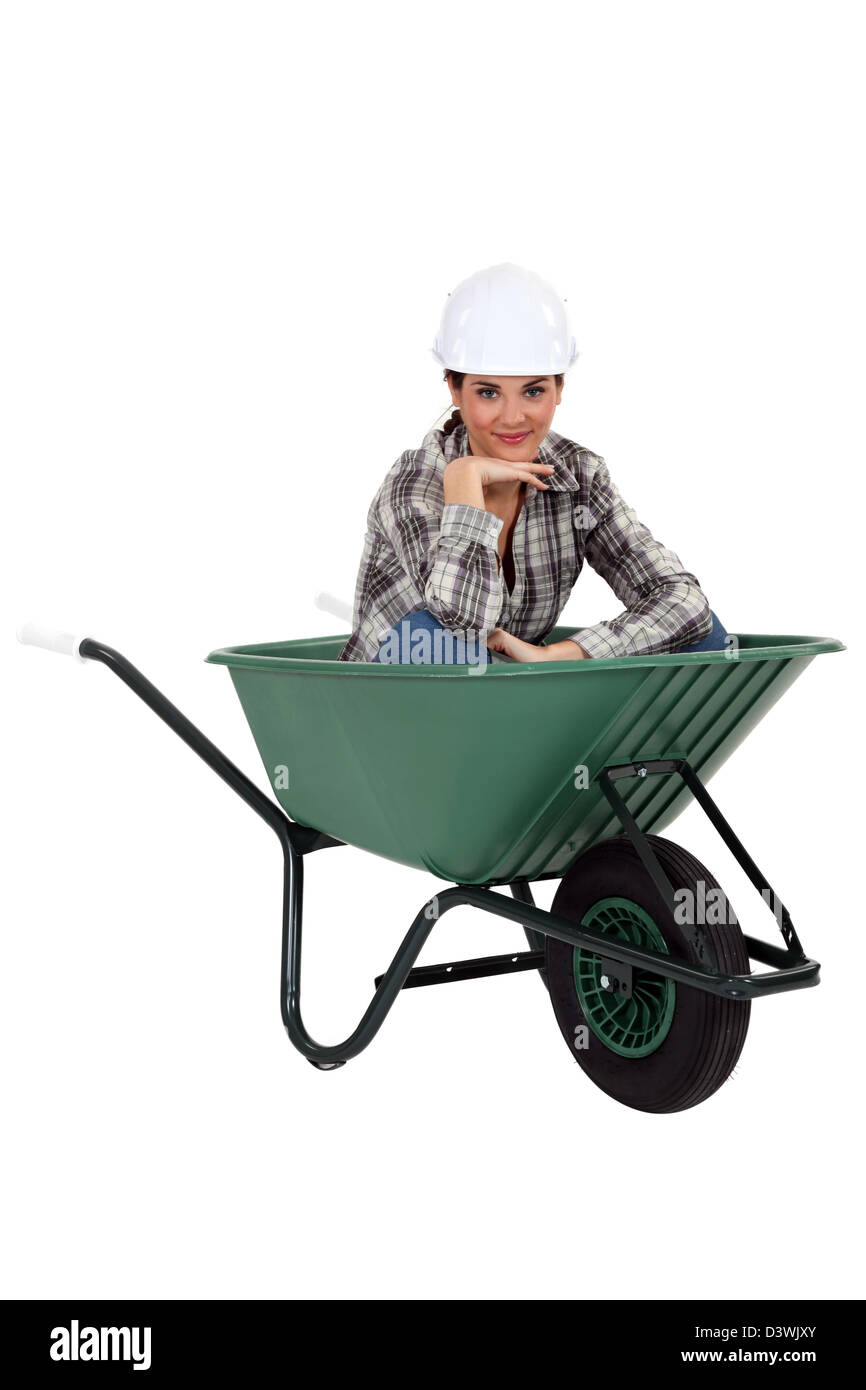 Tradeswoman sitting in a wheelbarrow Stock Photo - Alamy