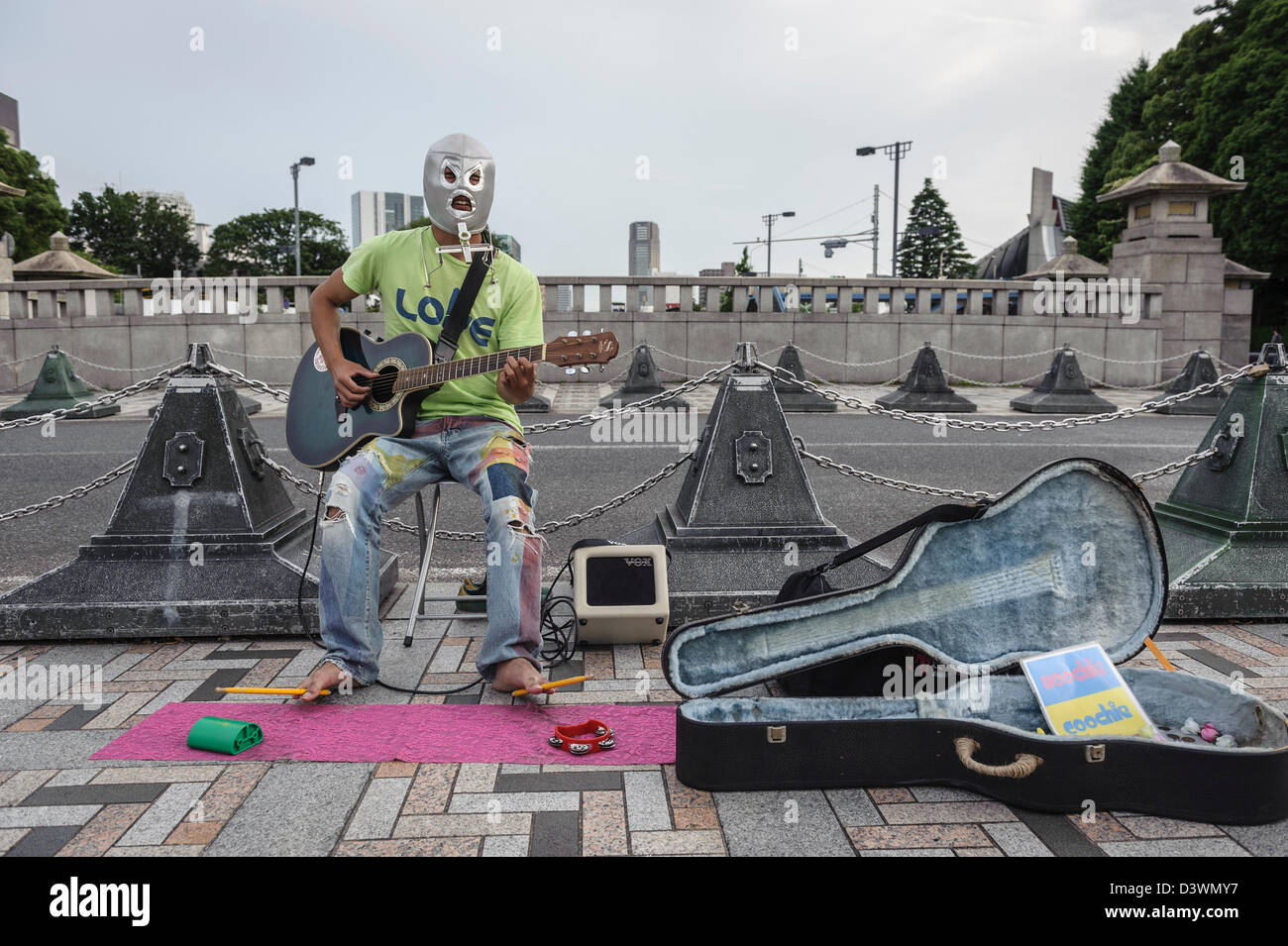 Man with a mask playing guitar nearby Yoyogi park, Tokyo, Japan, Asia Stock Photo