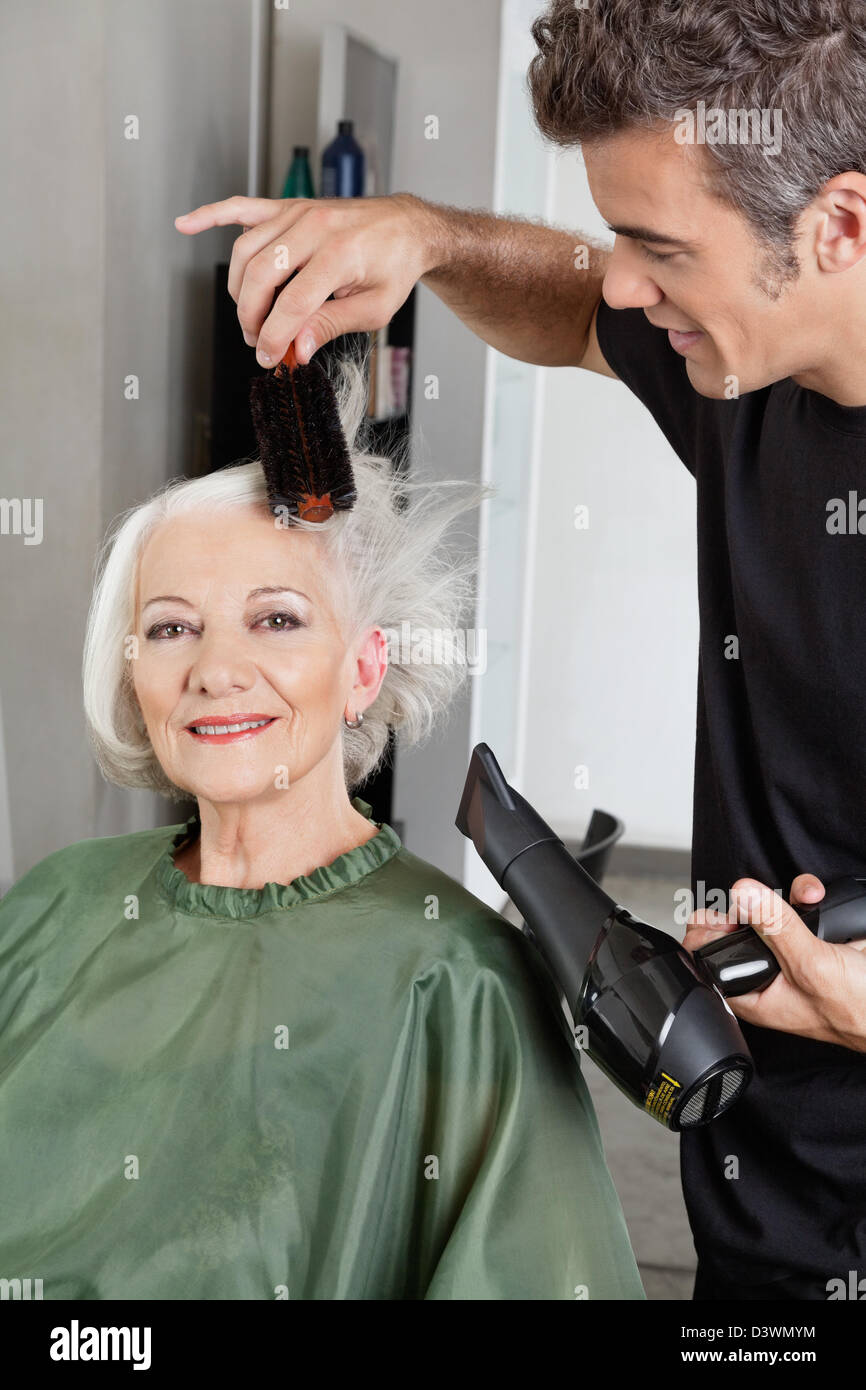 Mature woman blow drying hair hi-res stock photography and images - Alamy