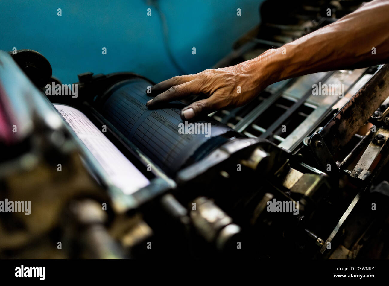 A Colombian master printer works on the letterpress machine in the print shop in Cali, Colombia. Stock Photo
