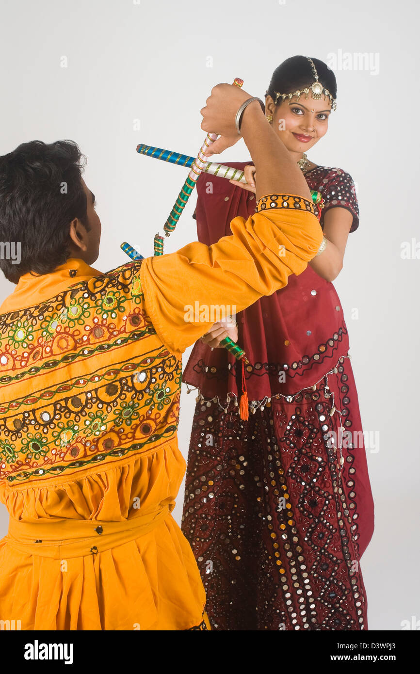 Couple performing dandiya Stock Photo - Alamy