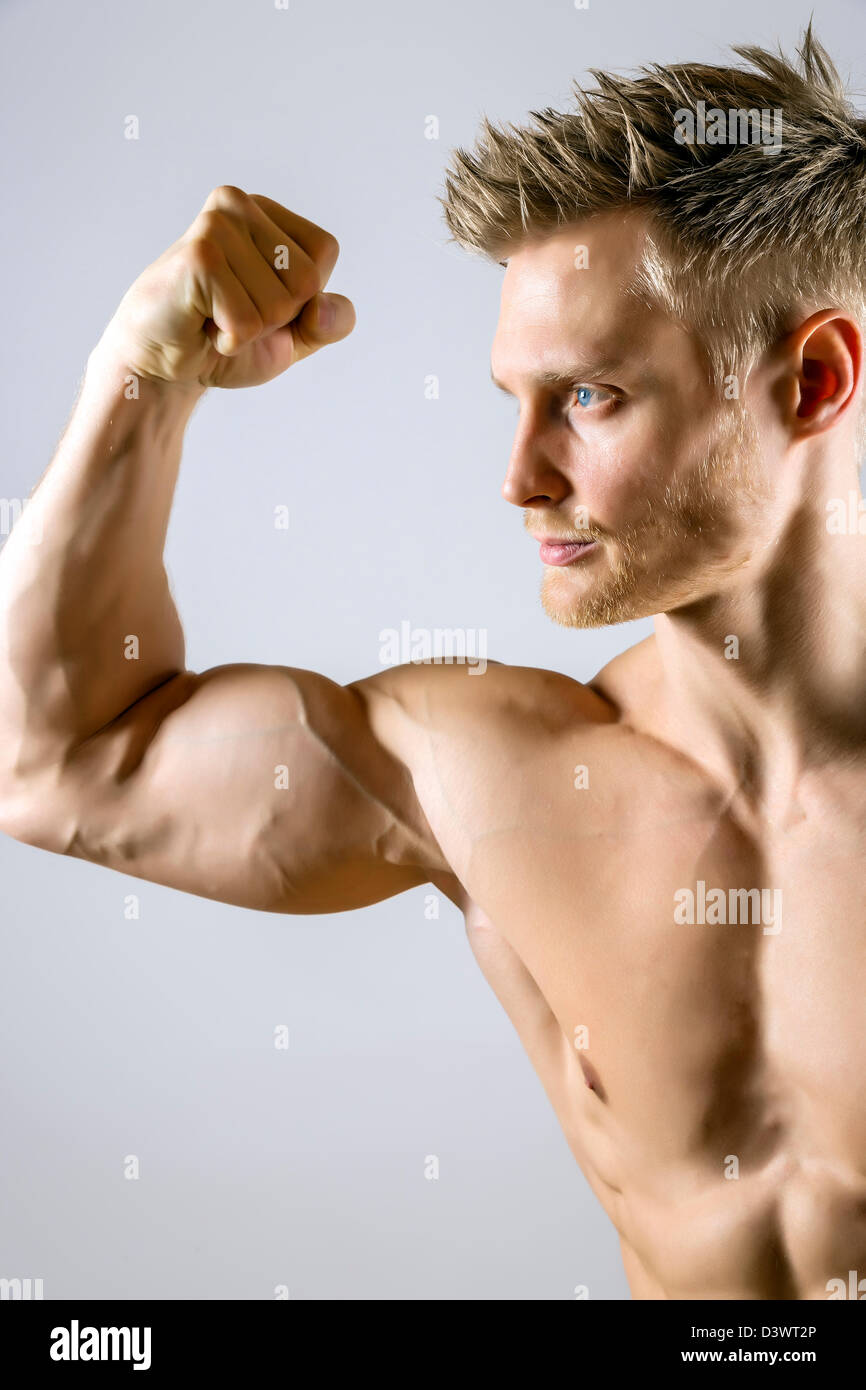 A muscular young man with short blonde hair, wearing a spandex