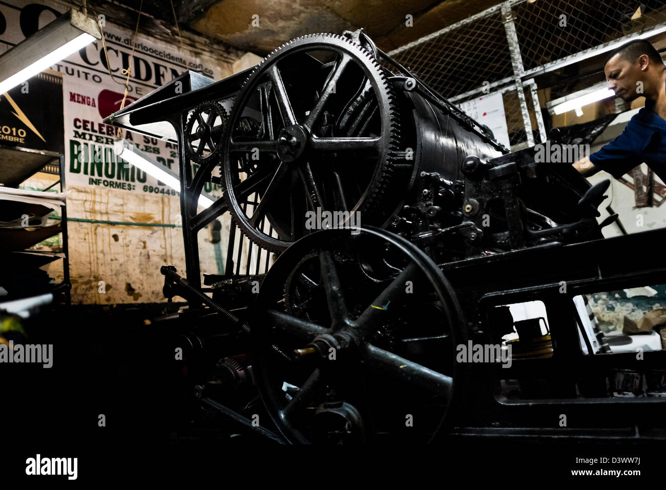 A Colombian master printer works on the ancient letterpress machine in the print shop in Cali, Colombia. Stock Photo