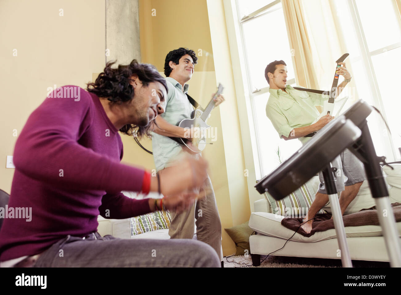 Mexian-American Men Friends Playing Rock Band Music Video Game Stock Photo