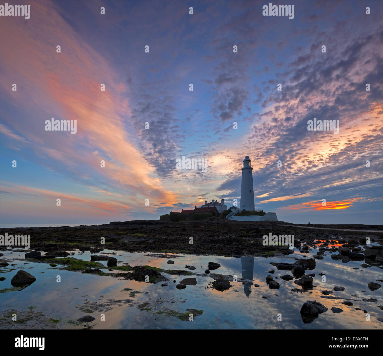 A dawn view of St Mary's Lighthouse and rock-pools at Whitley Bay, Tyne and Wear Stock Photo