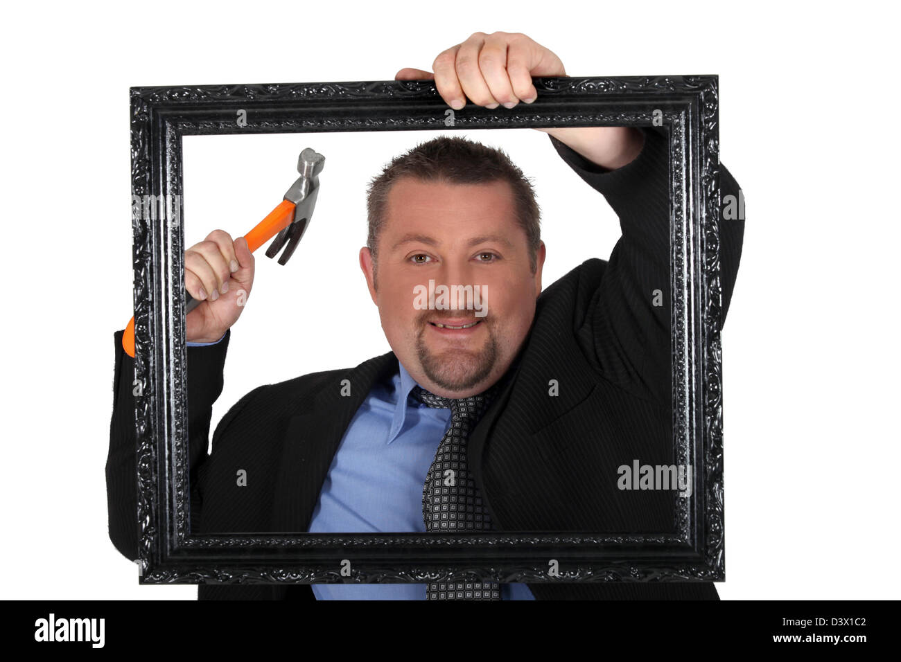 Man about to nail a picture frame to a wall Stock Photo Alamy