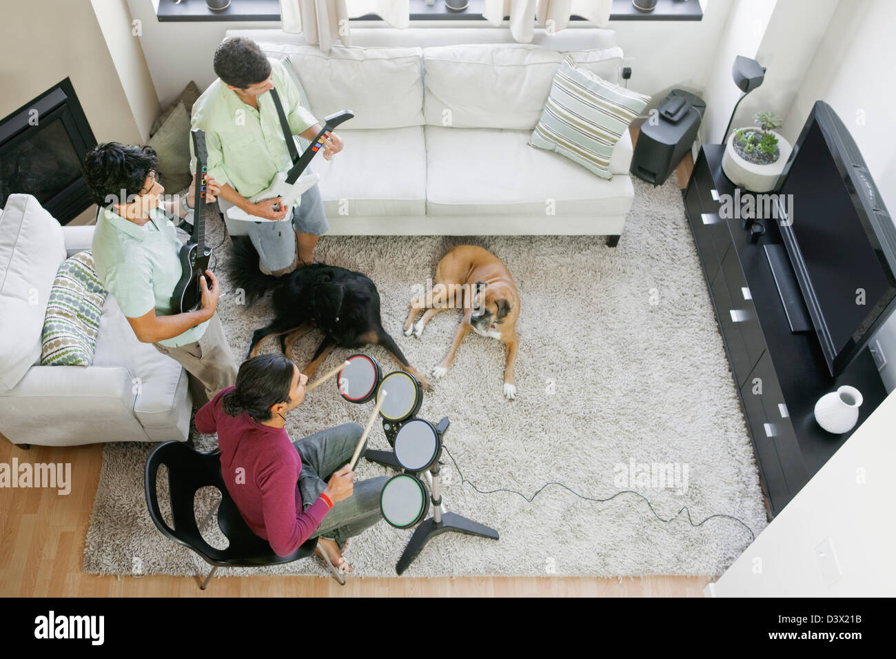 Mexian-American Men Friends Enjoying Playing Video Game on a Flat-Screen TV at Home Stock Photo