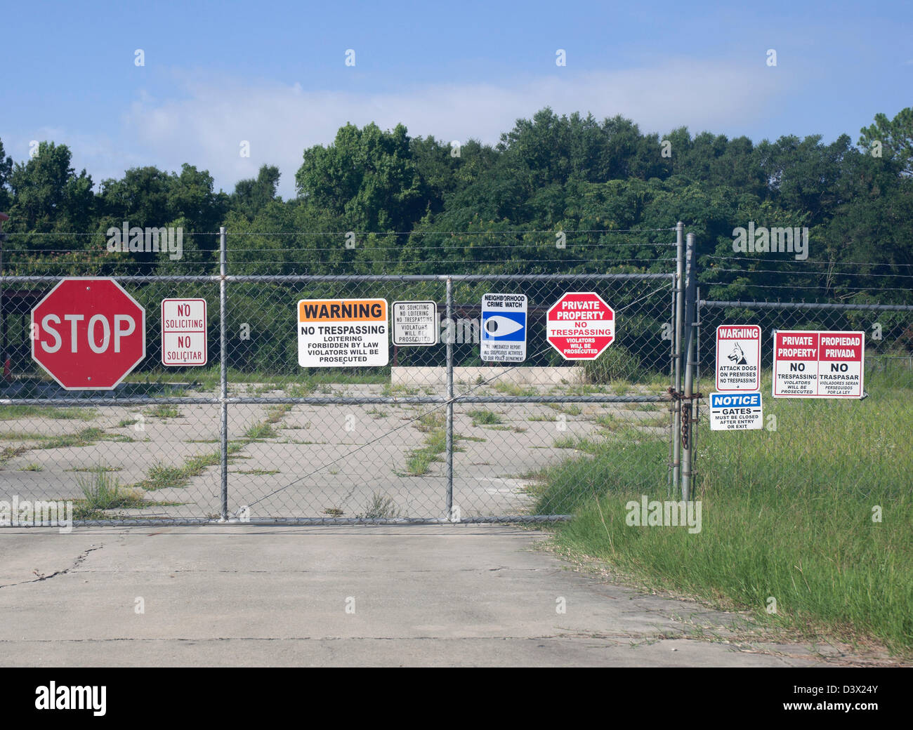 Warning signs and no trespassing signs at abandoned business site. Stock Photo