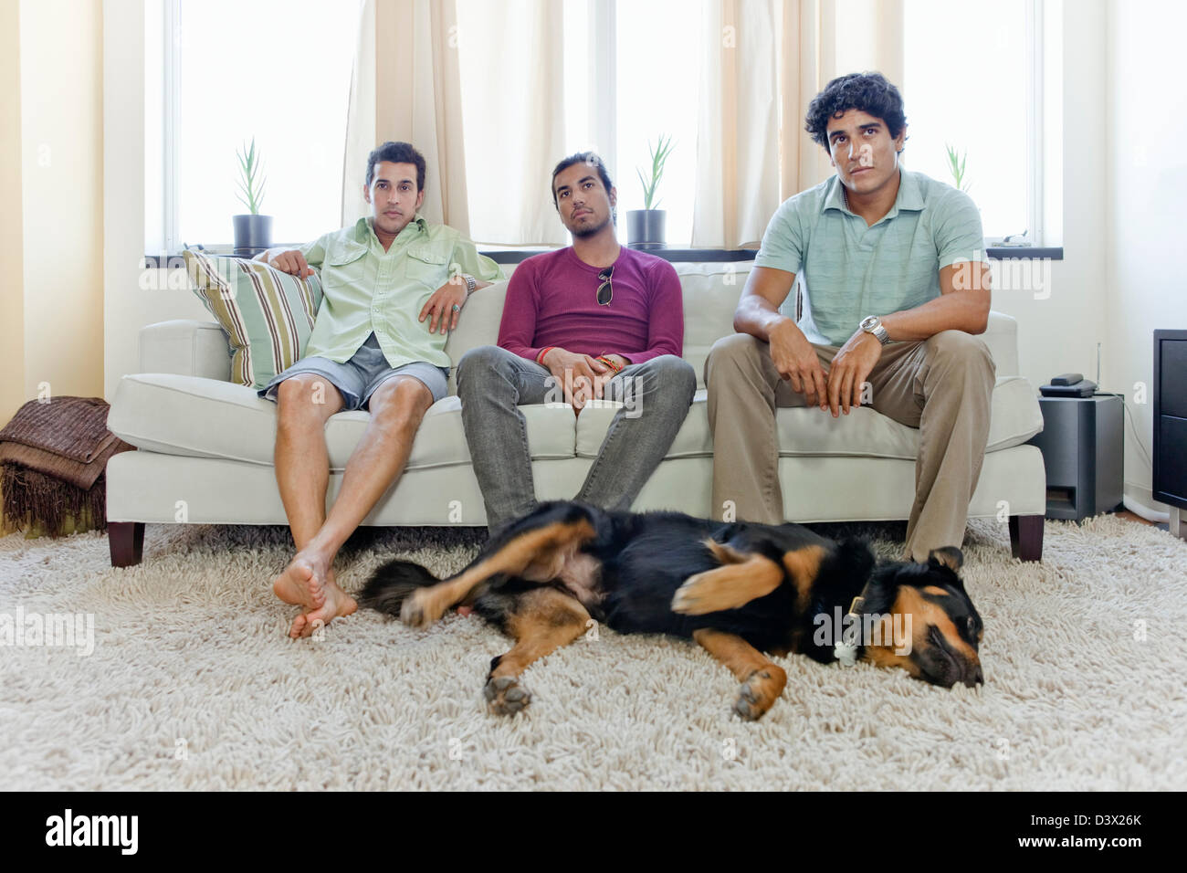 Young Latin-Hispanic Men, Sitting in Living Room Waiting, Bored Stock Photo