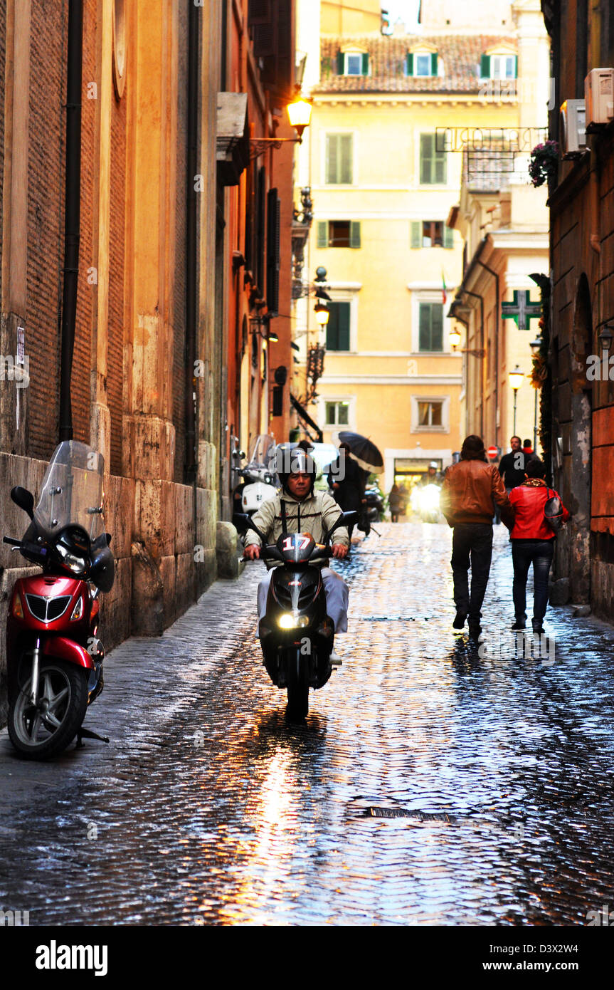 Rome street view, a moped on wet cobbles, Italy Stock Photo