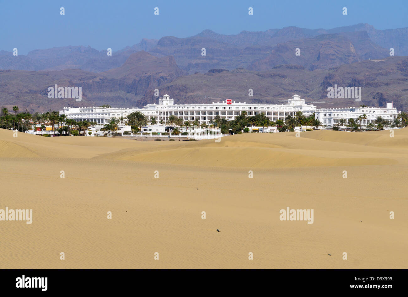 Riu Hotel seen with sand dunes in foreground and mountains in background Playa del Inglés, Gran Canaria Stock Photo