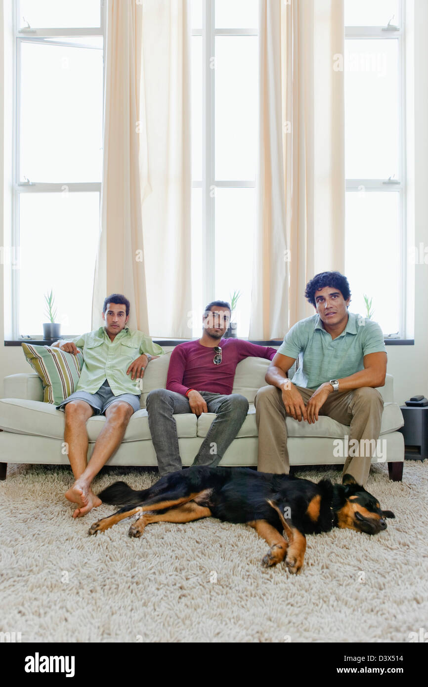 Young Hispanic-American Men, Sitting in Living Room Waiting, Bored Stock Photo