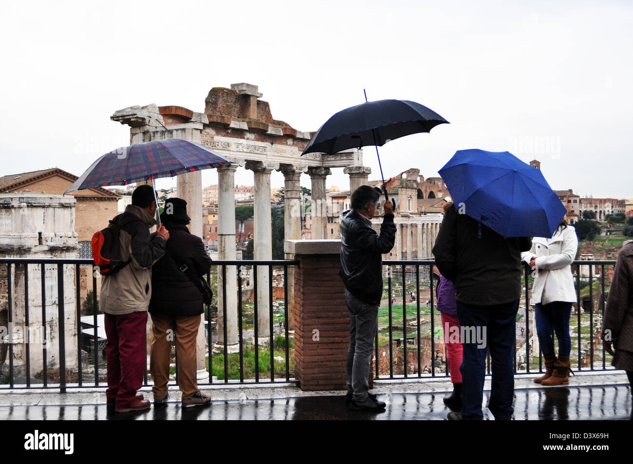 Tourists view the Roman Forum under umbrellas, Rome, Italy Stock Photo