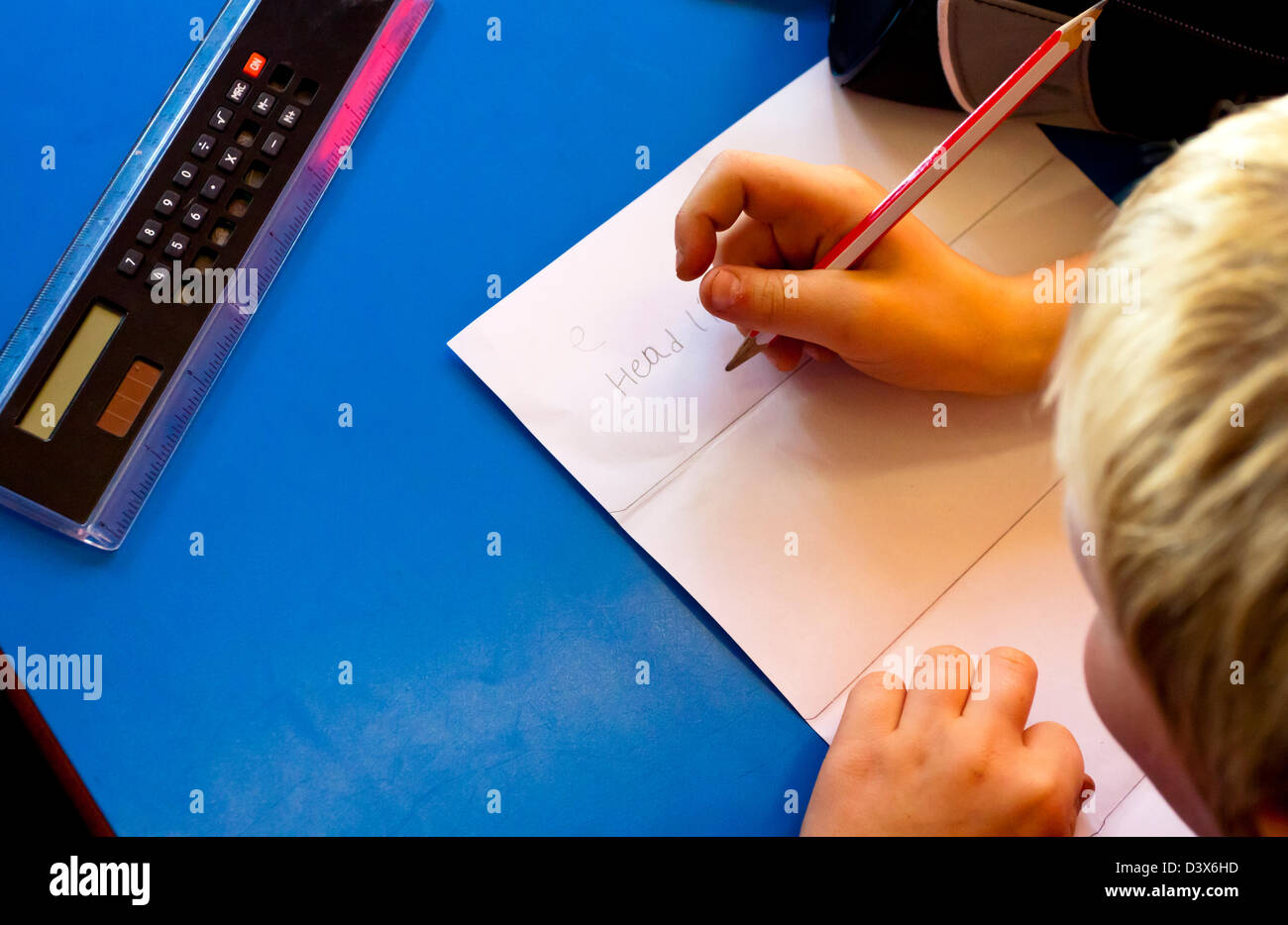 Detail of junior school child writing on a sheet of paper during a lesson Stock Photo