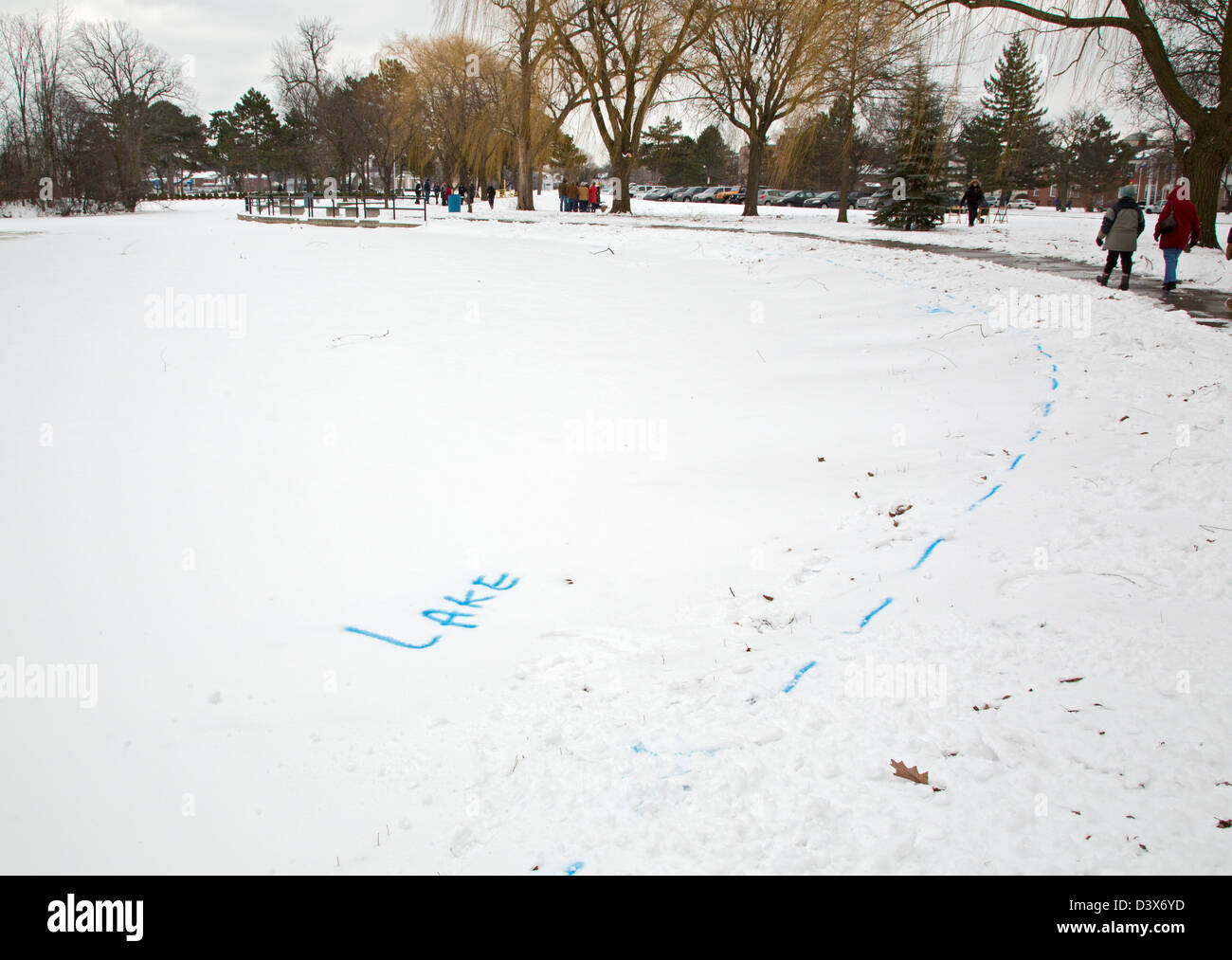 The shoreline of a lake in a city park is outlined so visitors to a winter festival do not wander onto very thin ice. Stock Photo