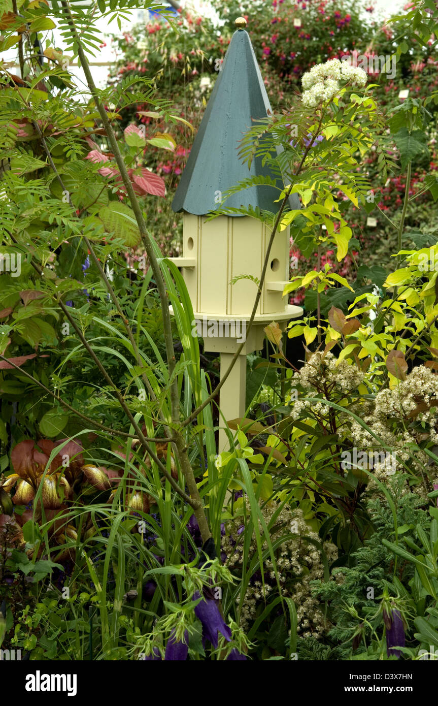 Bird box of stylish design, suitable as a garden feature too, sited within a mixed border. Stock Photo