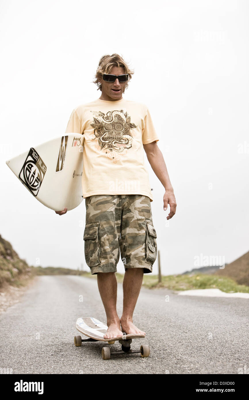 Surfer on skateboard, St Agnes, Cornwall, UK Stock Photo