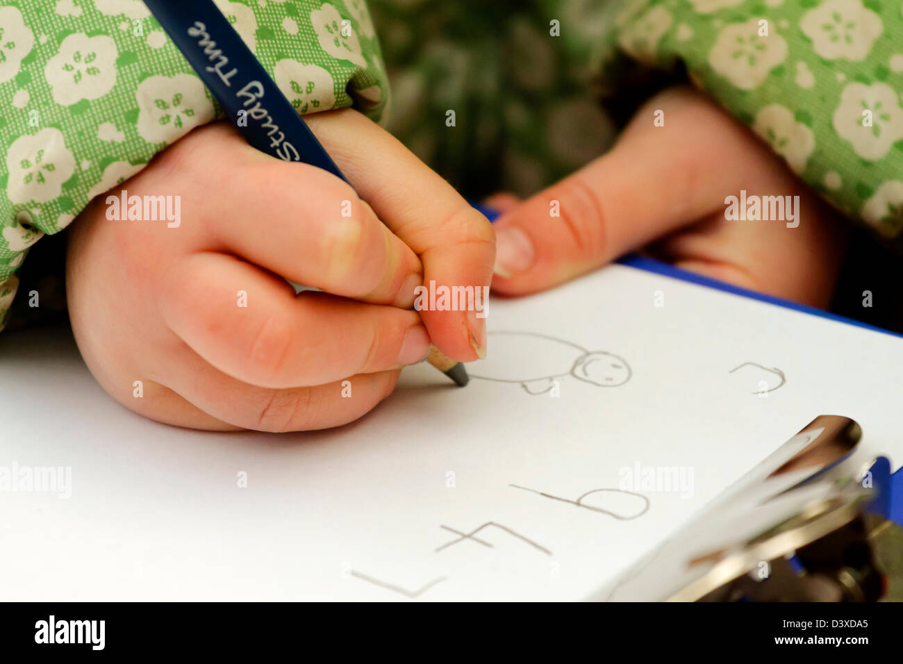 Detail of junior school child writing on a sheet of paper during a lesson Stock Photo