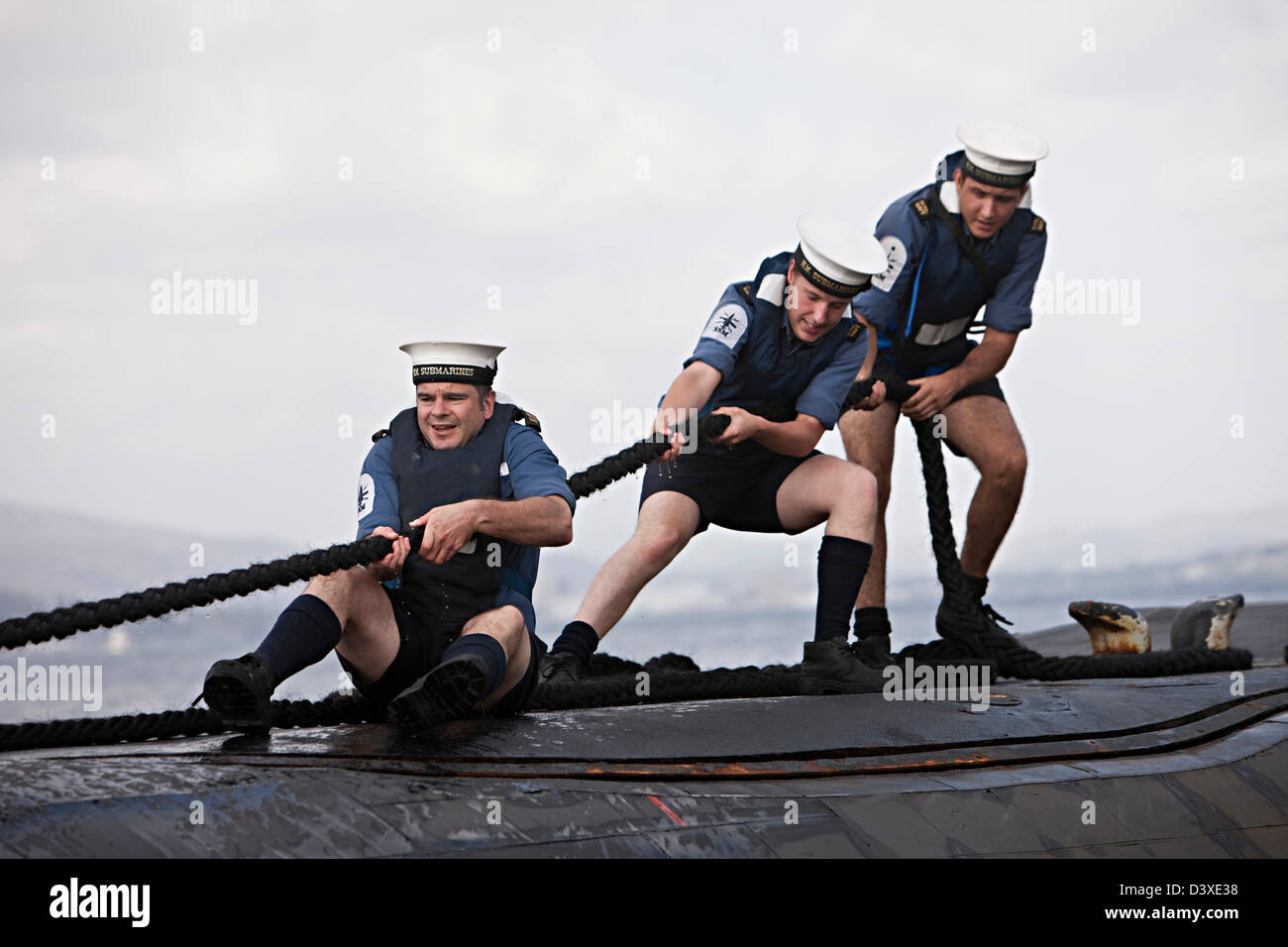 Three sailors pulling a rope on deck of Nuclear Submarine HMS Talent, Egypt Stock Photo