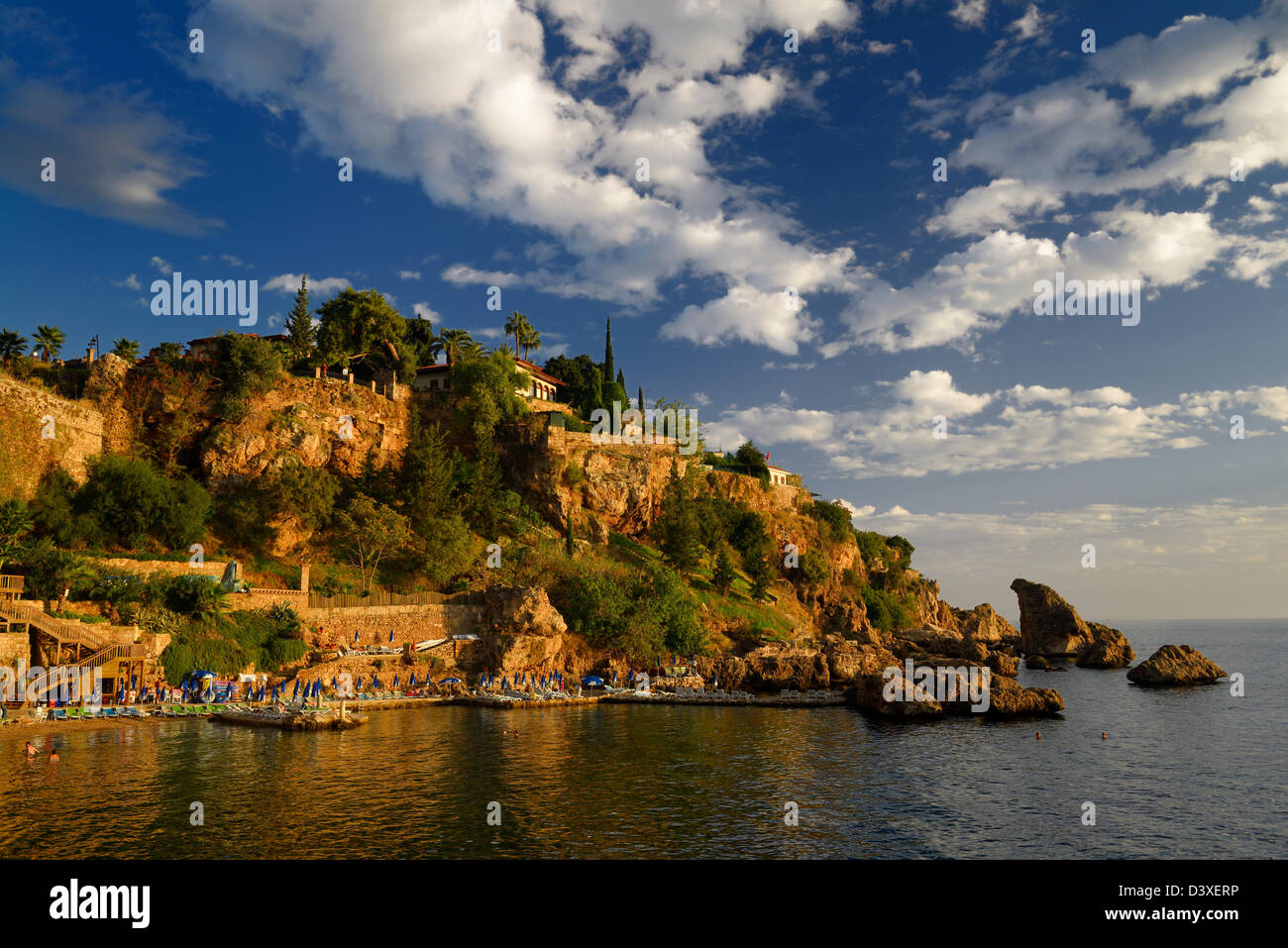 Cliffside resort and beach on Turkish Riviera at Antalya Kaleici Harbour Turkey at sunset Stock Photo