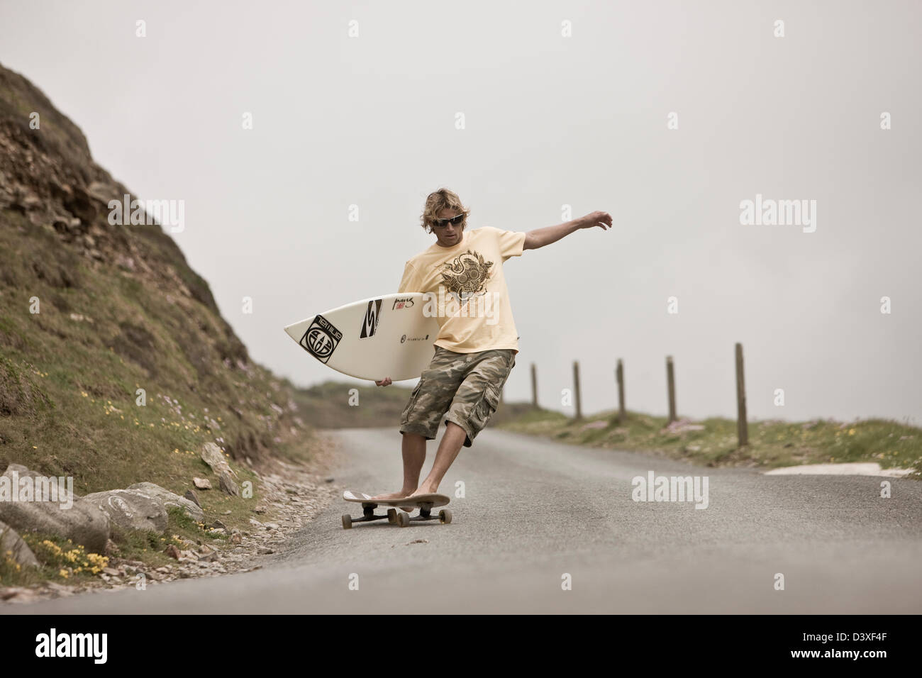Surfer on skateboard, St Agnes, Cornwall, UK Stock Photo