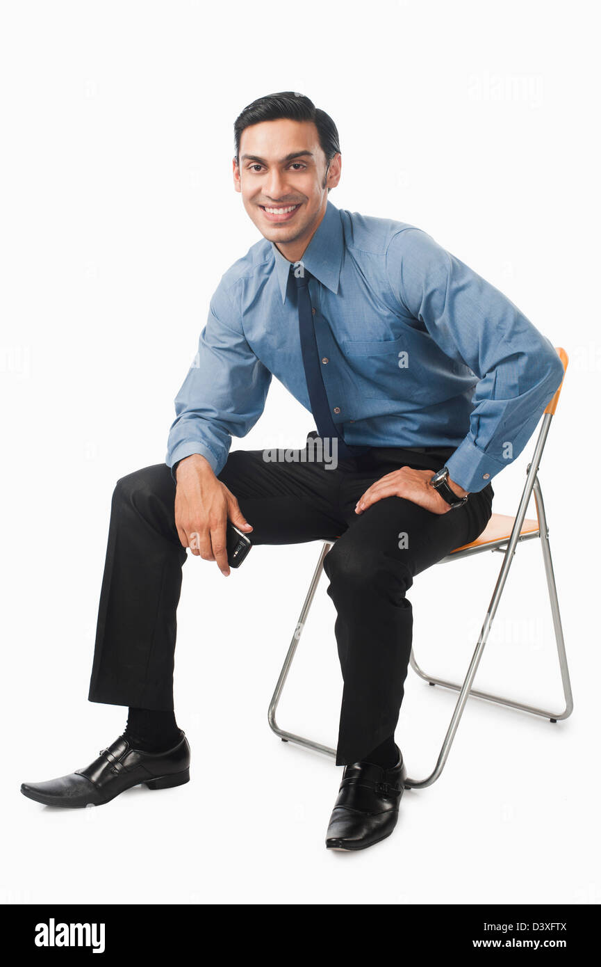 Bengali businessman sitting on a chair Stock Photo - Alamy