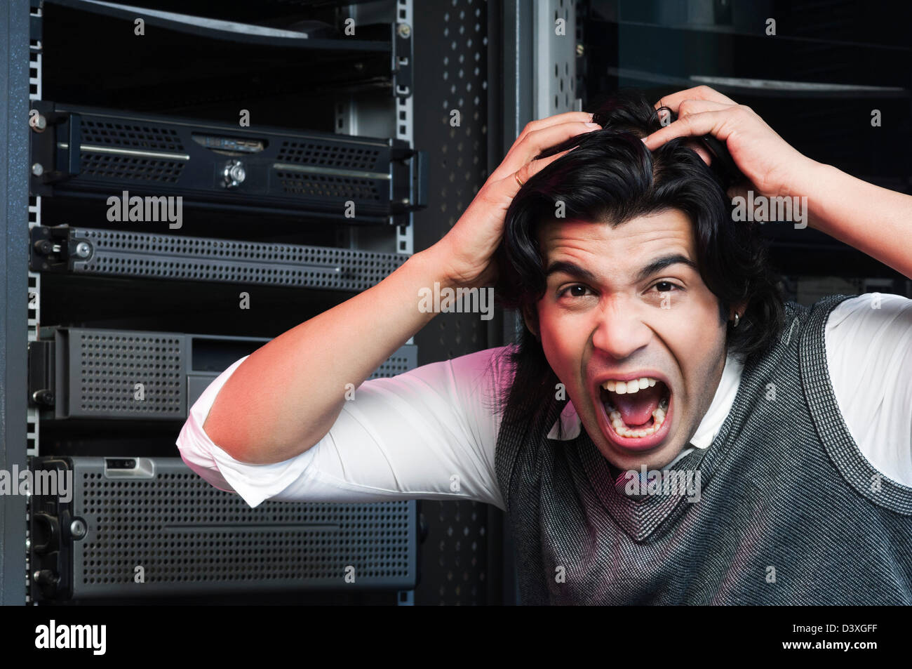 Frustrated networking engineer pulling his hair in a server room Stock  Photo - Alamy