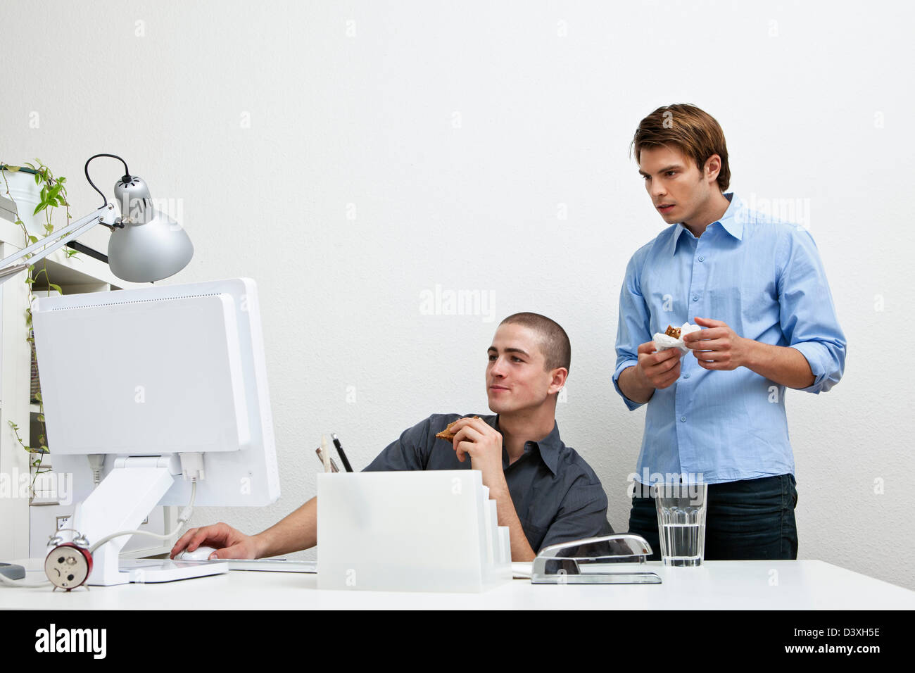 IT professionals working together on computer problems at lunch time Stock Photo