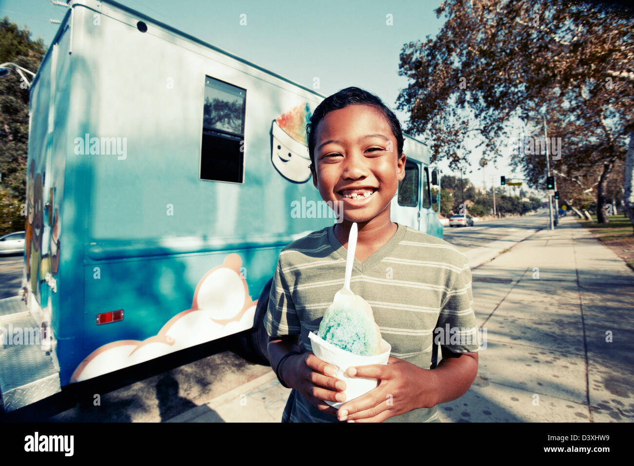 Mixed race boy eating ice cream from truck Stock Photo