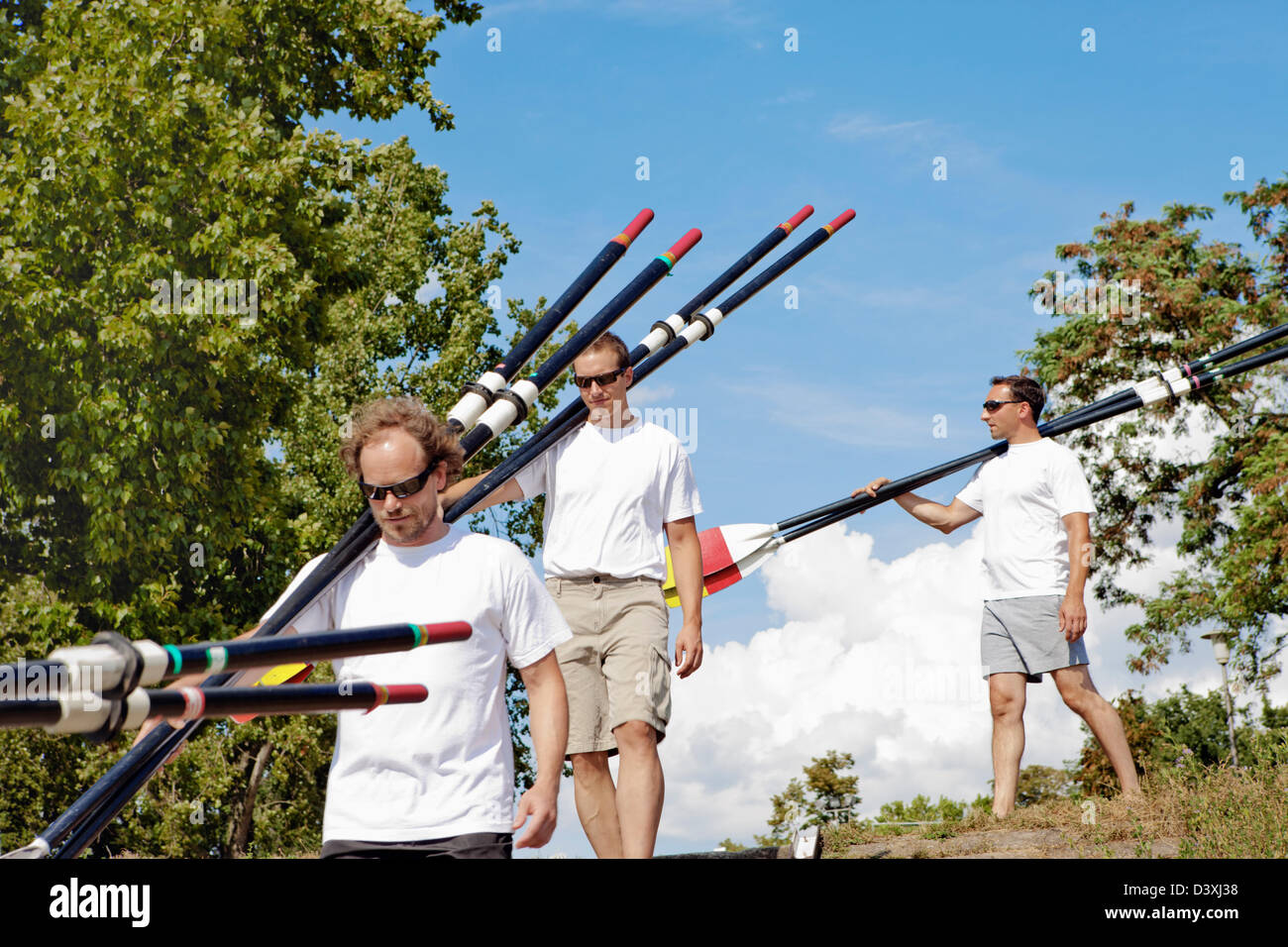 Teamwork Concept of Men Rowing Team Setting Paddles in Preparation Stock Photo