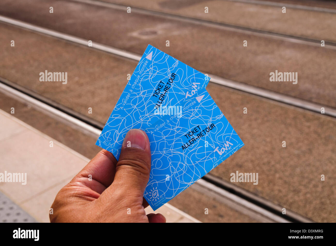 Man's left hand holding two tram tickets, Montpellier, Hérault, Languedoc-Roussillon Stock Photo