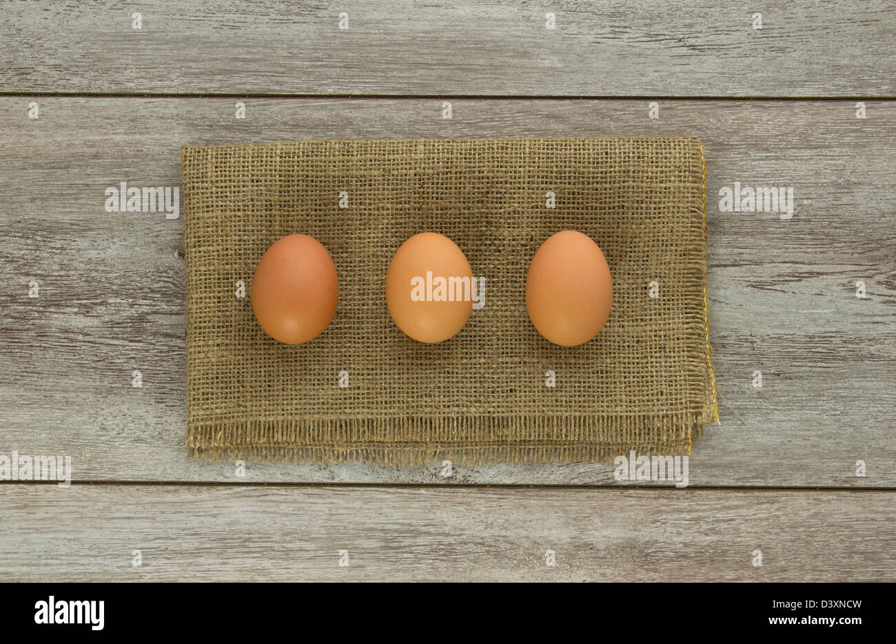 Three brown chicken eggs on burlap and weathered boards Stock Photo - Alamy