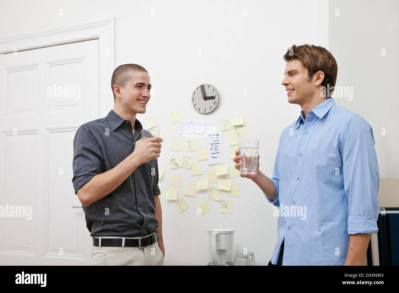 Office workers chatting in the pantry while taking a break Stock Photo