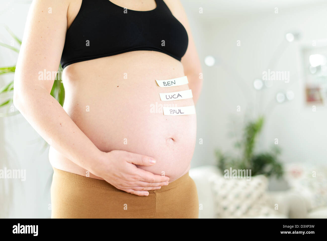 The most popular German boys' names on a baby belly of a pregnant woman. Stock Photo