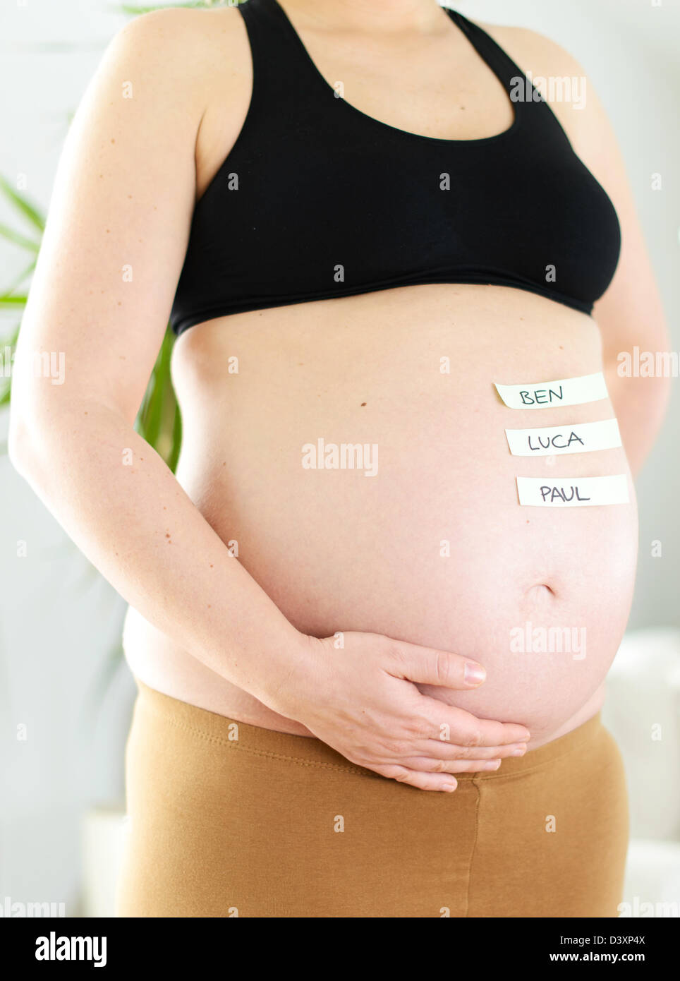 The popular German boy names on a baby belly of a pregnant woman. Stock Photo