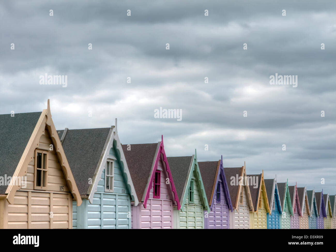 Mersea, Essex. Row of brightly coloured traditional  beach hut Stock Photo