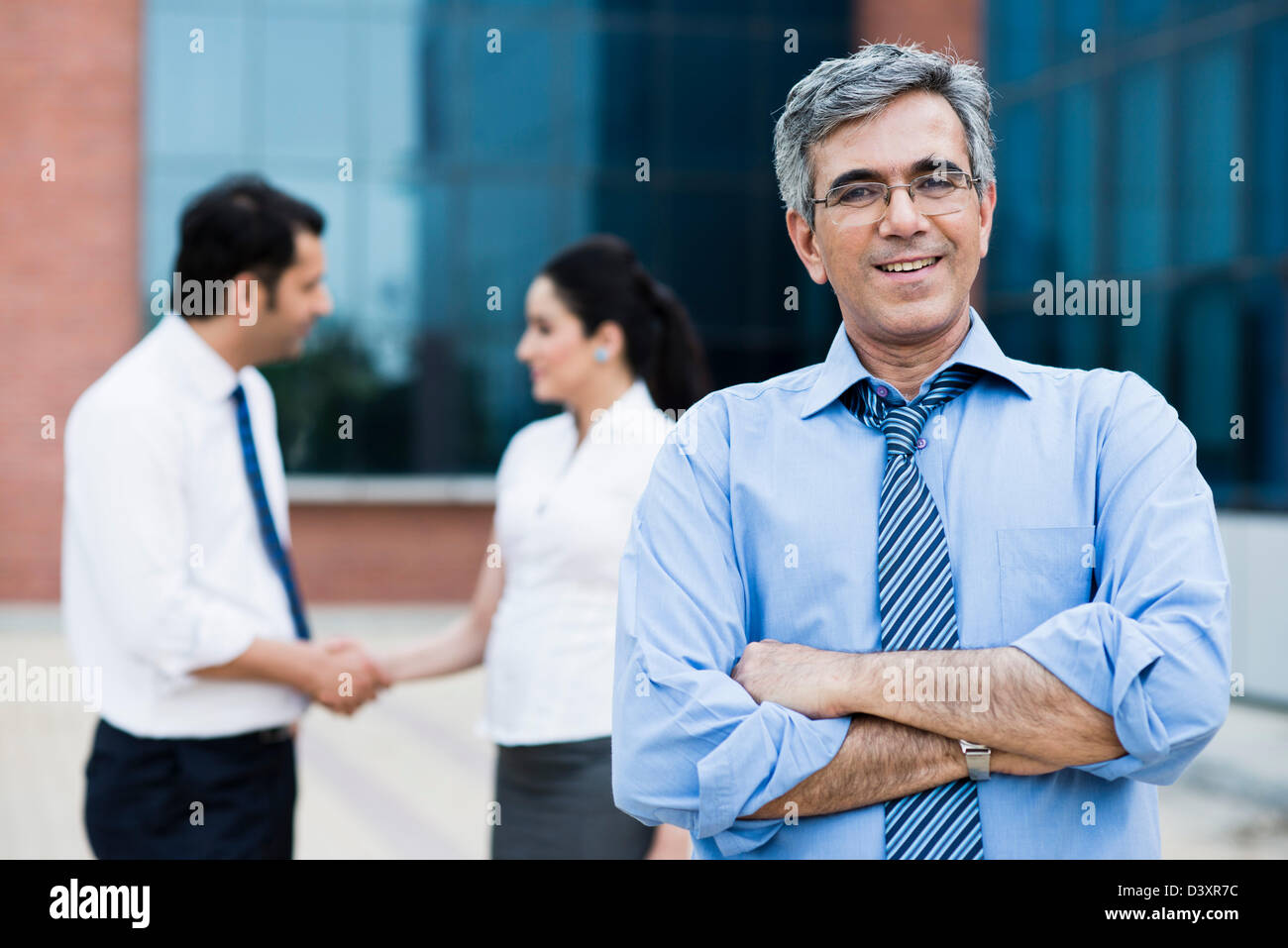 Portrait of a businessman with his colleagues standing behind him Stock ...