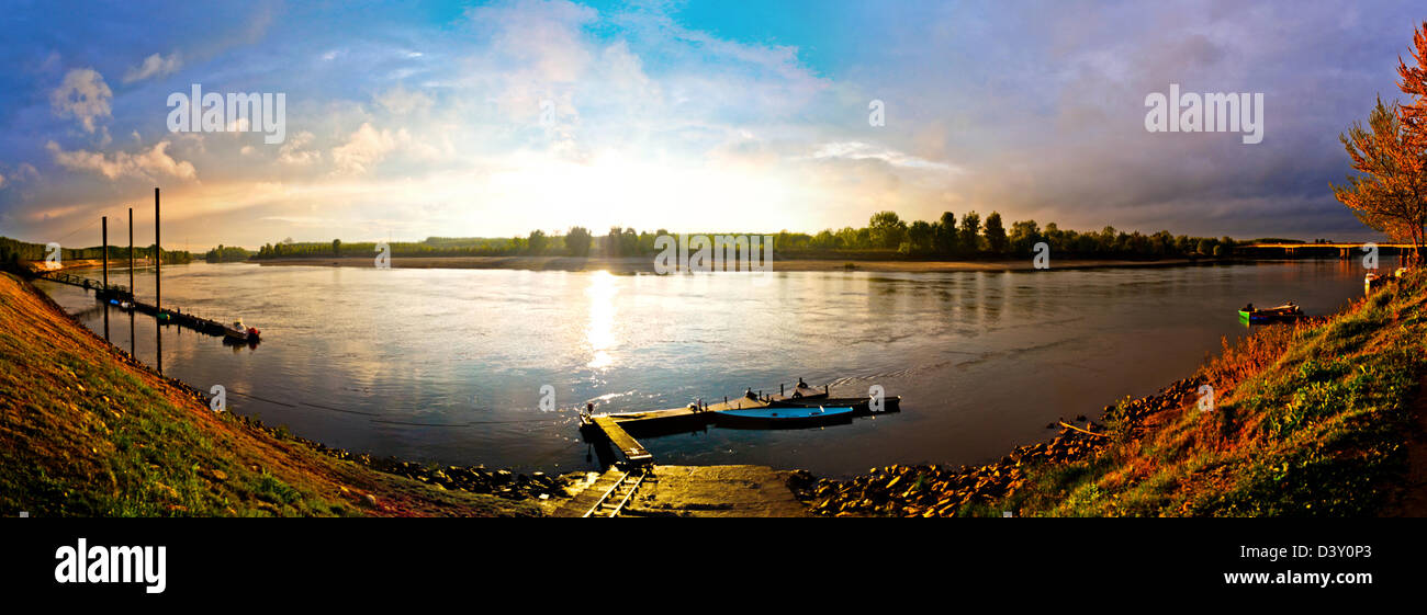 sunset colours reflected on Po river, Italy's biggest river with boats Stock Photo
