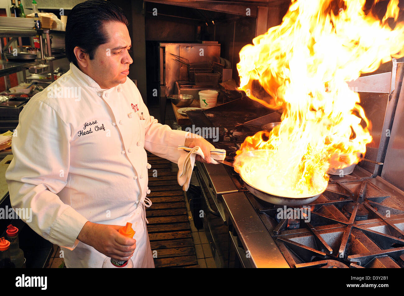 A Chef flames up a Chicken Scarperiello dish in his kitchen in New Haven CT USA Stock Photo