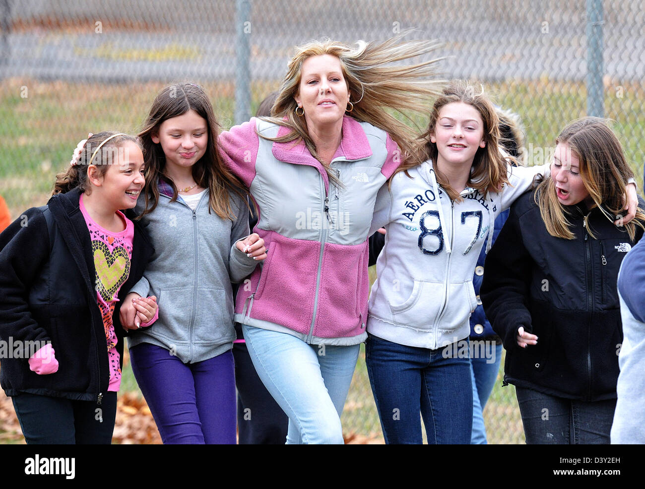 Parents and students walk cheerily as they raise money for a parent of ...