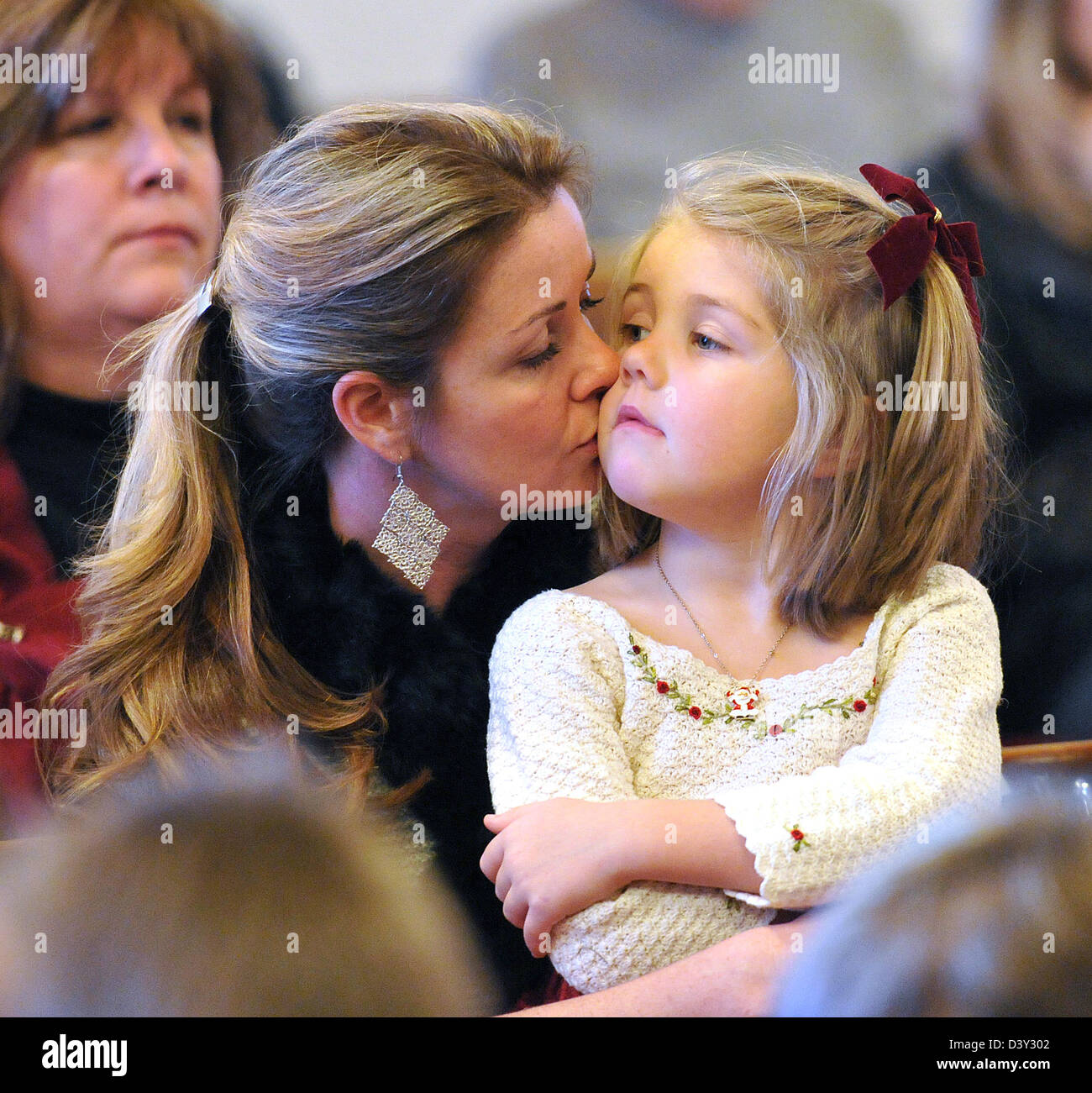 North Haven, CT USA--4-Year-old Nola Coyle gets a kiss from her mother, Mary Coyle, during the Children's Christmas pageant. Stock Photo