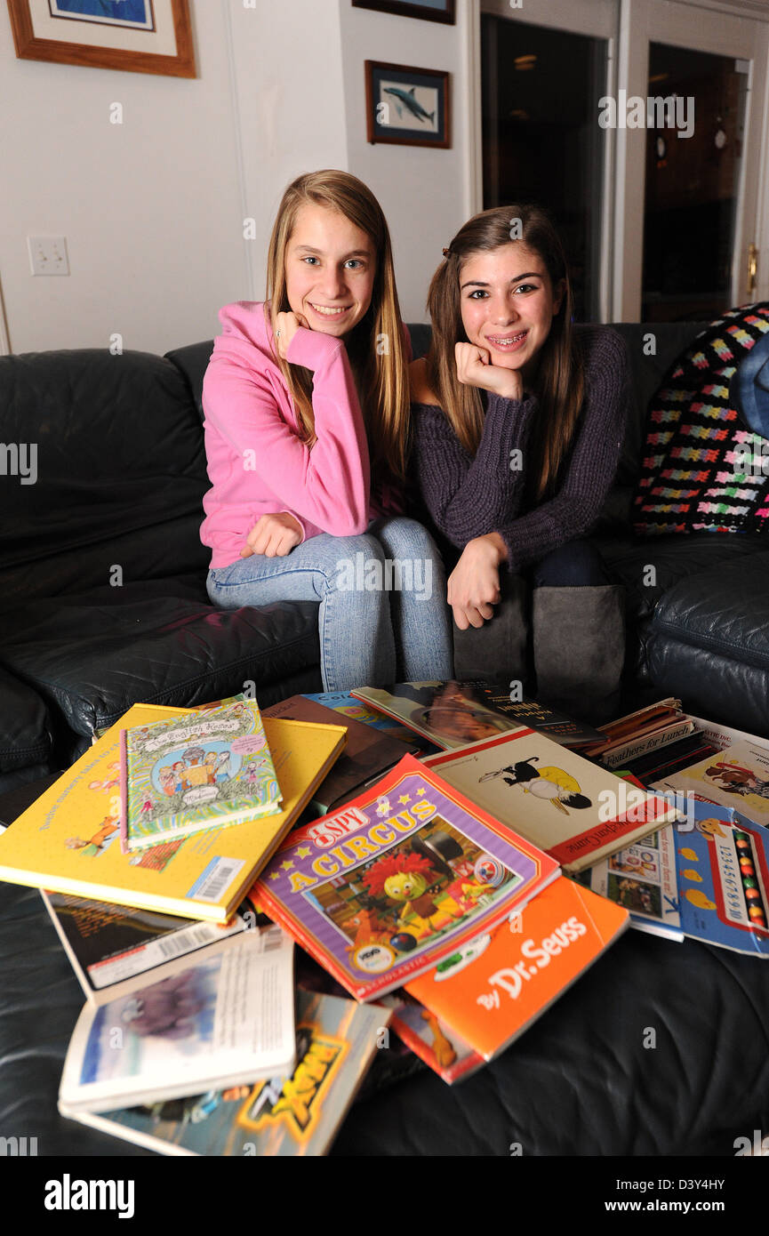 Teenage girls helping the need by collecting books for donation in CT USA Stock Photo