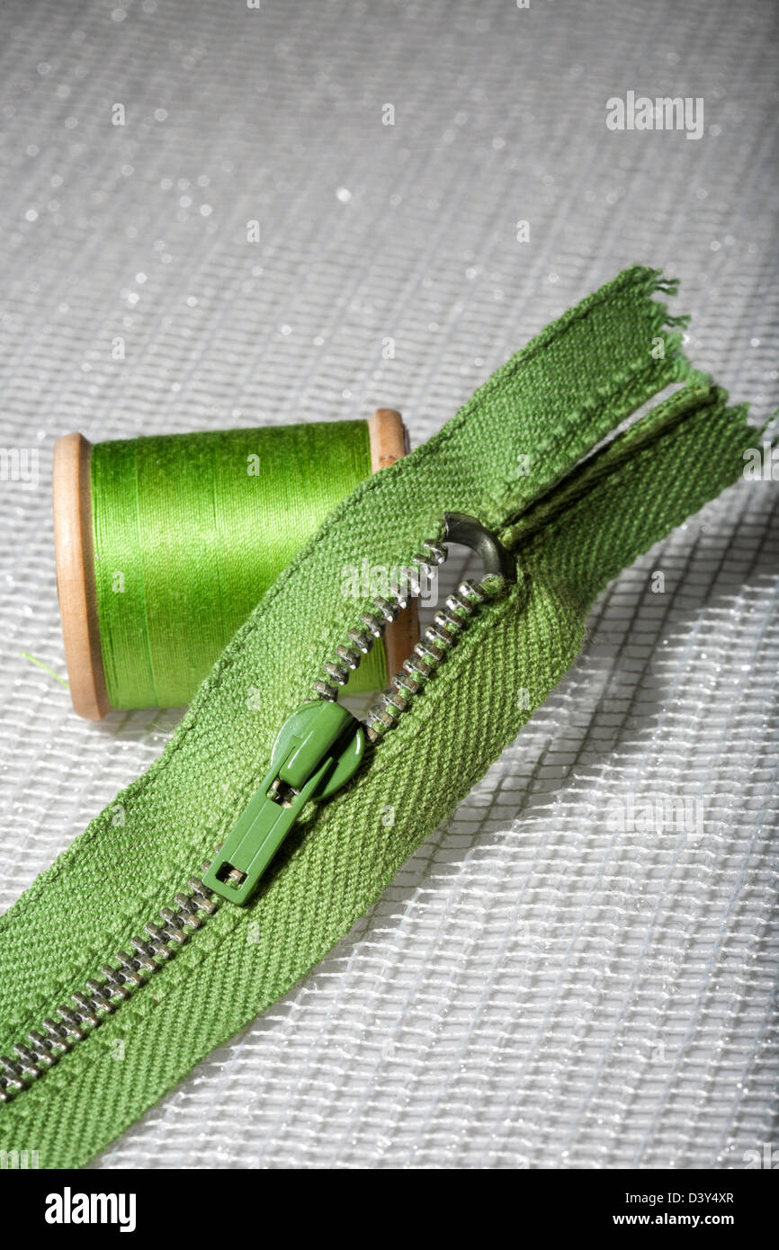 Isolated wooden spool of green thread with a needle 8414070 Stock