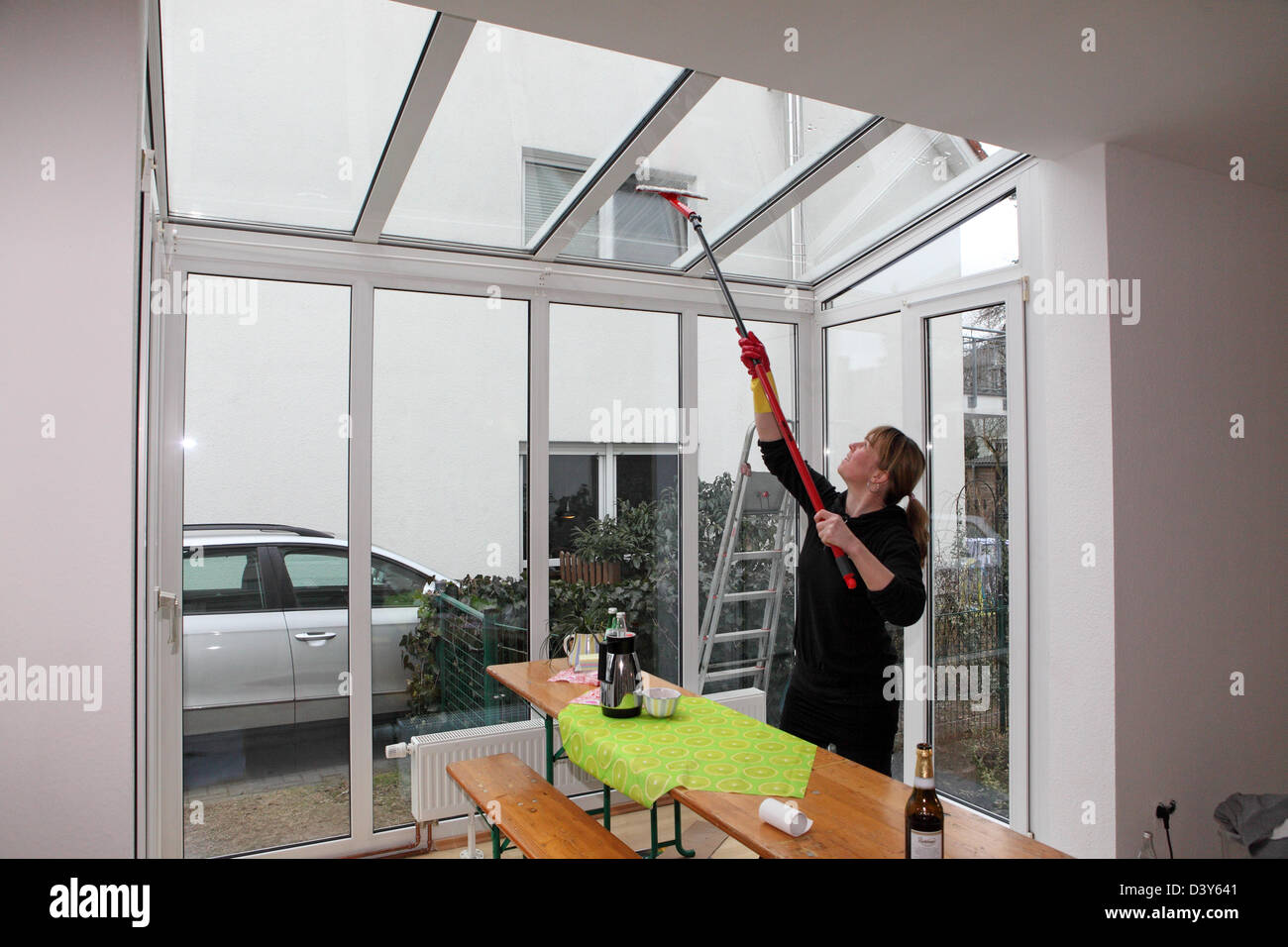 Berlin, Germany, woman dressing the windows in your conservatory Stock Photo