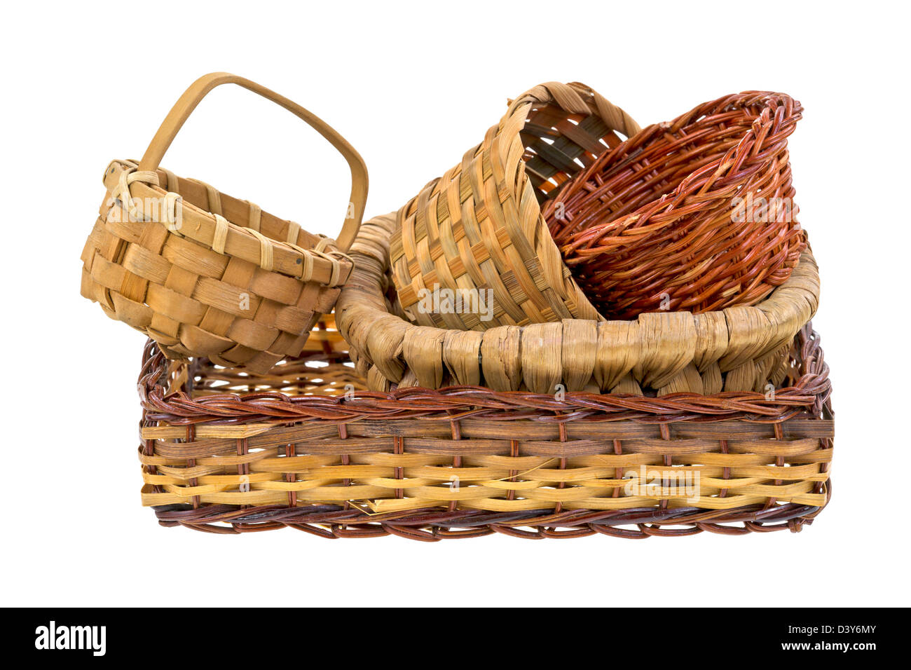 Several wicker baskets stacked inside a larger wicker basket on a white background. Stock Photo
