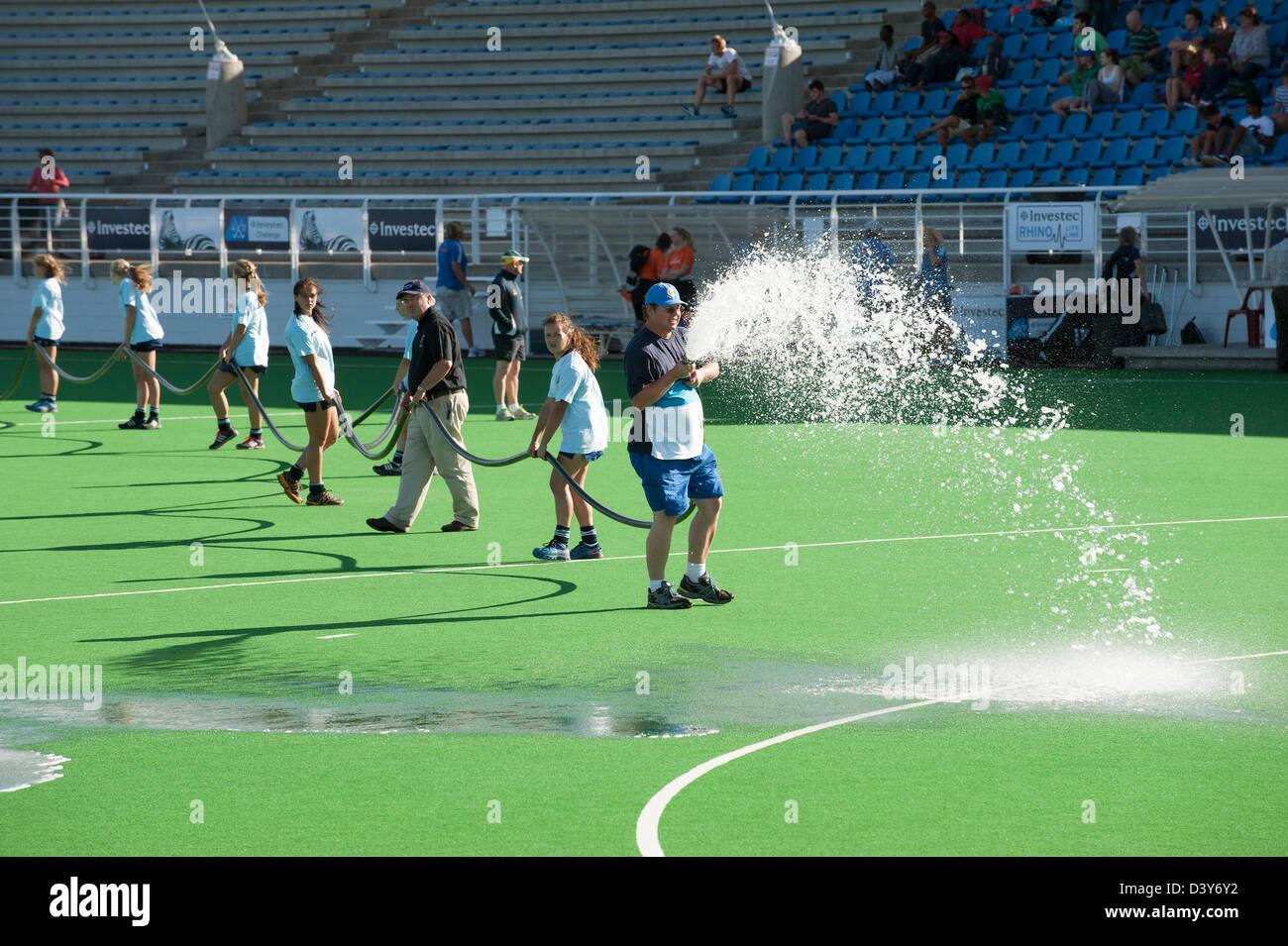 Groundstaff water the artificial pitch at Hartleyvale hockey stadium Cape Town South Africa pitch field preparation Stock Photo