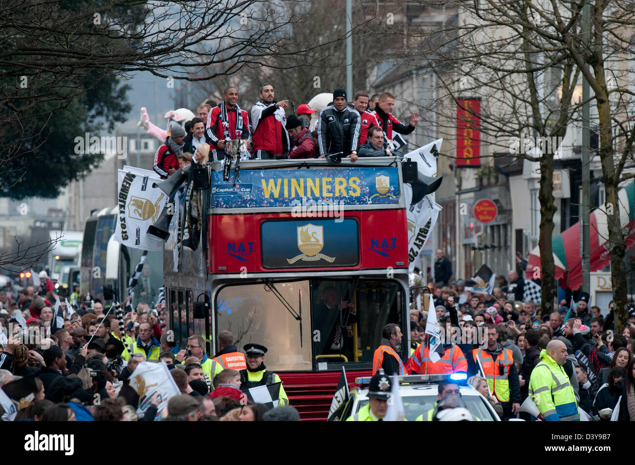 Swansea, Wales, UK. 26th February 2013. Swansea City Football team and fans celebrating during an open-top bus parade through the centre of Swansea after beating Bradford City 5-0 in Sunday's Capital One Cup final at Wembley to win the Capital Cup trophy. Credit:  Phil Rees / Alamy Live News Stock Photo