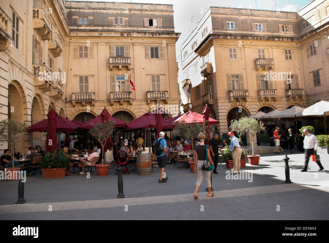 Tourist rest at outdoor cafes in Italian Renaissance patio by hotels and buildings Stock Photo